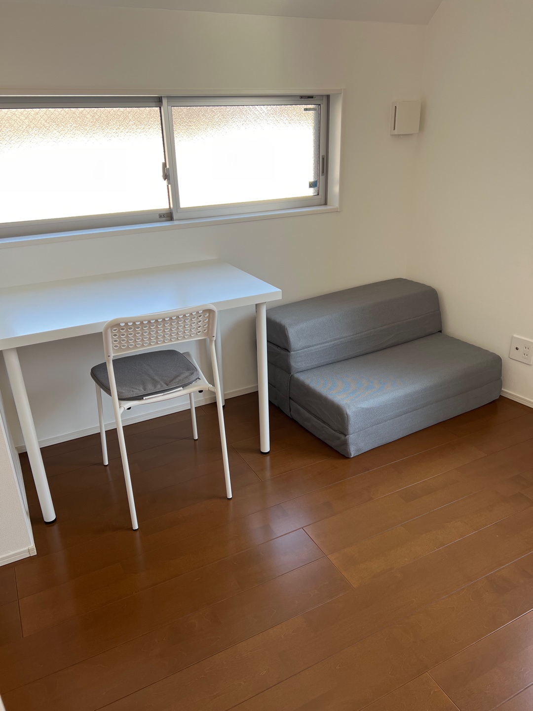 Bedroom with desk, chair, and convertible sofa in sofa mode