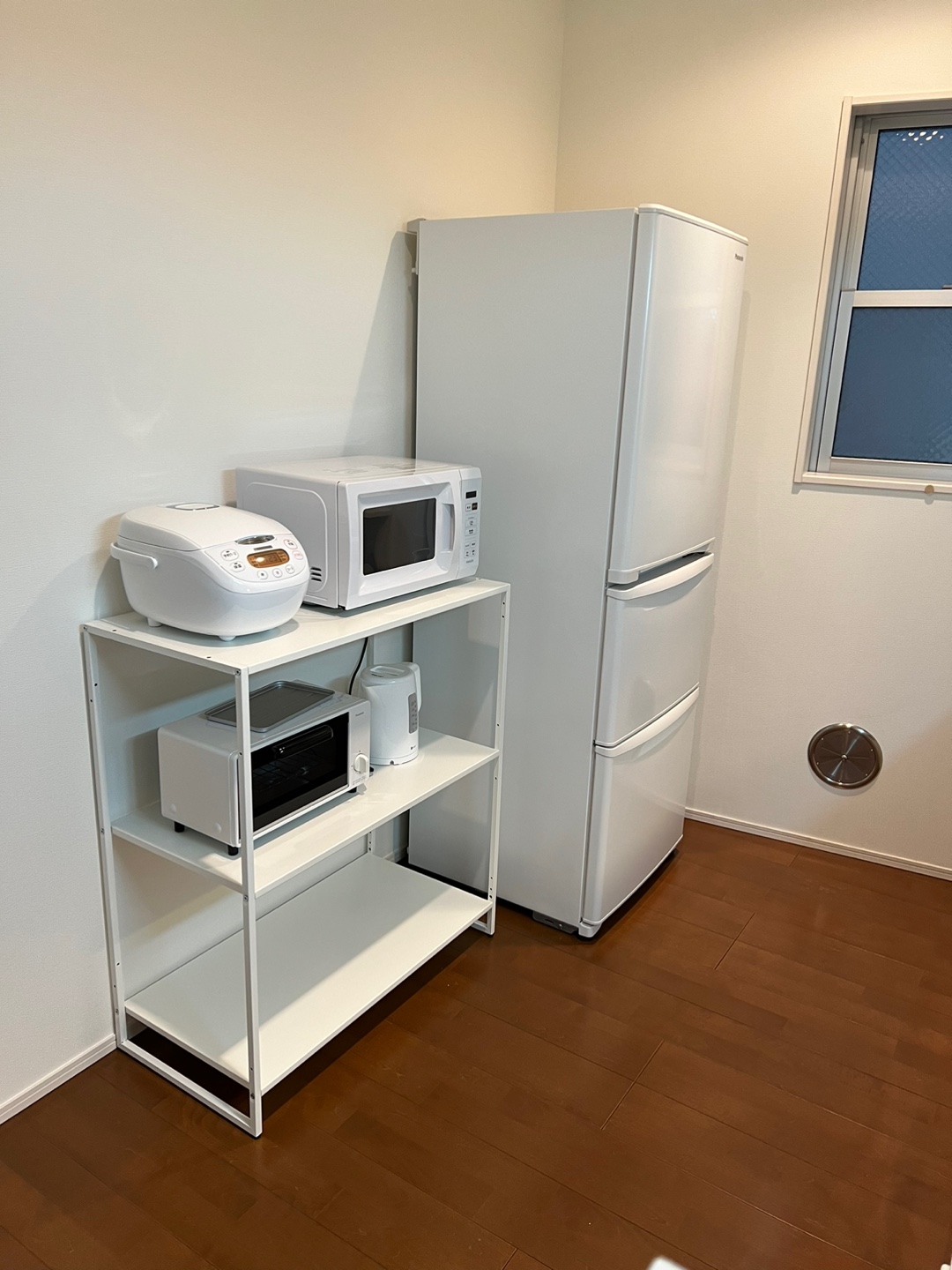 Kitchen appliances including fridge, microwave, and rice cooker